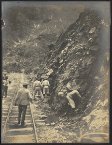 Men standing on railroad tracks