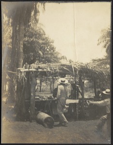 Men standing around hut