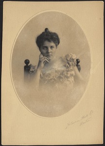 Isabel Stevens in white floral appliqué dress, seated