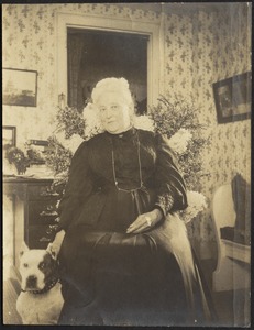 Harriet M. Cornwall Granger (Mrs. George Granger) seated in chair with dog
