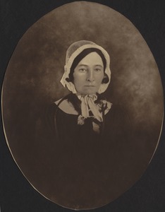 Early photo of middle-aged woman in white bonnet and dark dress