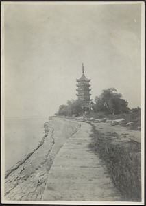 View of sea wall with walkway, temple in distance