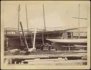 Boat yard — two wooden sailing vessels in dry dock
