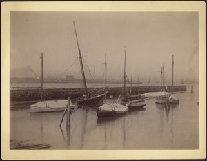 View of sailboats docked near stone pier; Ownenee listing to the side