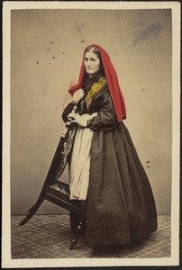 Studio portrait of woman in traditional dress holding chair
