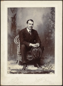 Studio portrait of U. S. Consul Adelbert S. Hay seated holding hat and cigarette