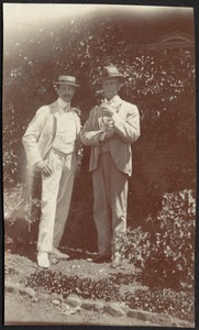 Two well-dressed gentlemen standing in garden