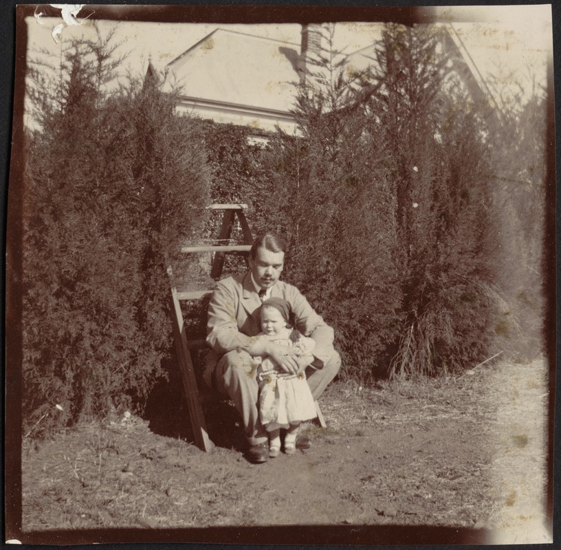 Consul Adelbert S. Hay sitting on step ladder holding small child