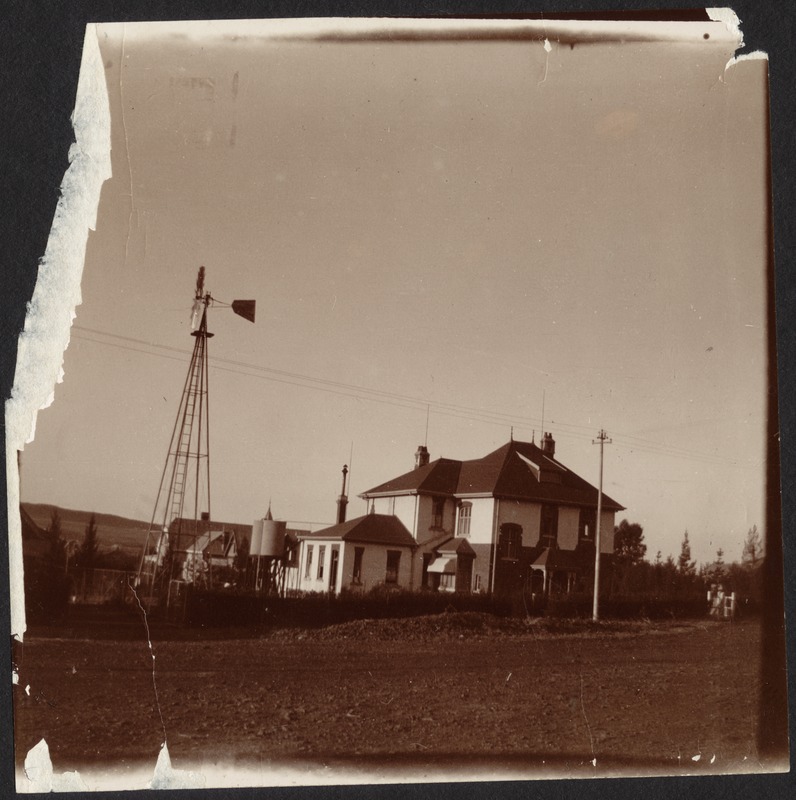 White house with windmill and small water tanks