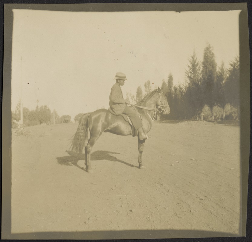 African boy w/hat on horseback