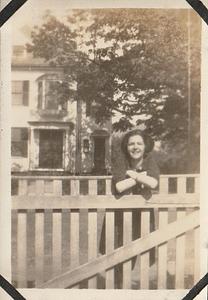 Unidentified woman leaning on a fence