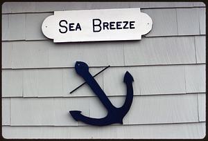 "Sea Breeze" sign and representation of anchor on wall