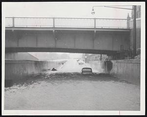 Flooded Underpass - A late model car sits stalled in two feet of water on Storrow Drive at the Massachusetts avenue underpass at the height of yesterday's storm. The drive was blocked for hours, flooded at this and other points.