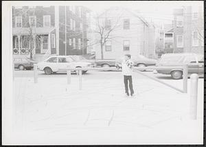 Boy standing in a square near a street