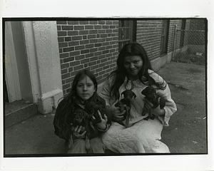 Woman and young girl holding four puppies