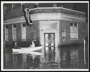 Firemen Break Out Oars-Peabody firefighters were among the first to launch boats as waters began to climb against front of downtown buildings like this one.