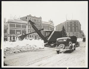 Power shovel pressed into service to remove huge piles of snow in Kenmore square, yesterday.