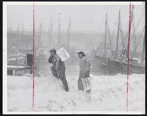 Iceman Cometh In Blizzard - Despite blizzard sweeping Boston, these fishermen clambered over drifts to stock up their vessel with ice. Trucks were unable to get close to dock due to deep snow. Fishing fleet is tied up awaiting end to storms but fishermen are preparing to get an early start.