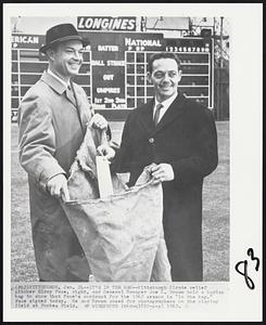It's in the Bag -- Pittsburgh Pirate relief pitcher Elroy Face, right, and General Manager Joe L. Brown hold a burlap bag to show that Face's contract for the 1962 season is "in the bag." Face signed today. He and Brown posed for photographers on the playing field at Forbes Field.