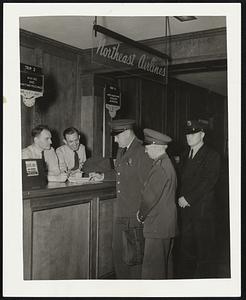 Immigration Officers Scan Passenger Lists. Regulations regarding German nationals leaving the country were considerably tightened yesterday, following an edict from Washington. Photograph snapped at ticket counter of Northeast Airlines at Boston Airport shows local immigration officials checking passenger lists of Northeast planes from Boston to Moncton, New Brunswick; and from Boston to Montreal. The immigration officials, left to right, are: Franklin K. Riley, Charles R. Wilmot, and Guard Nelson LeRay. Ticket Agents Wesley Stuart, and Earle Berbrick of Northeast Airlines are furnishing passengers lists.