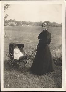 Woman with baby in stroller in farm field