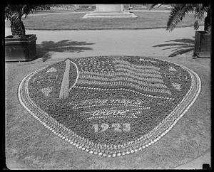 Flowerbed showing a flag with inscription "Long May It Wave 1923" underneath, Boston Public Garden