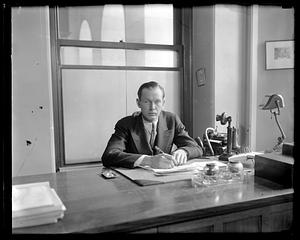 Unidentified man sitting behind a desk