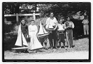 Boys holding model sailboats