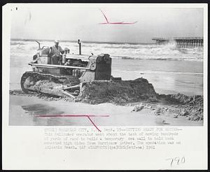 Getting Ready for Esther -- This bulldozer operator went about the task of moving hundreds of yards of sand to build a temporary sea wall to hold back expected high tides from Hurricane Esther. The operation was on Atlantic Beach.