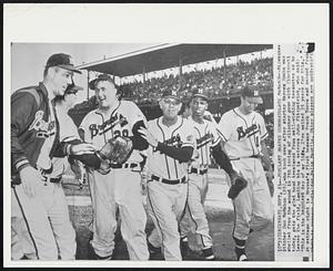 Jubilant Braves Congratulate McMahon--Milwaukee pitcher Don McMahon (20), who took over after starter Warren Spahn was shelled from the mound in 7th inning of clincher game with Cincinnati today, gets the glad hand treatment from well-wishing teammates as he leaves the field. Leading him is veteran John Fitzpatrick, who said: "This is the happiest day of my life. I've waited 35 years for this." At extreme right is Braves' first baseman Frank Torre and second from right is reserve infielder Felix Mantile. Other players are unidentified.