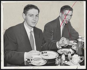 Building Up to Let the Bruins Down is Terry Sawchuk (left) of the Detroit Red Wings as he dines with Teammate Fred Glover at the Hotel Manager today. Terry, the top goalie in hockey, will be in nets against the Bruins tonight at the Arena.
