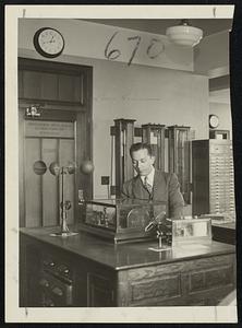 Weather Forecasting Edward Sable, Govt observer, studying anemometer readings inside the weather bureau.