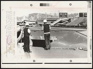 This is the Yellow printer showing highway workers inspecting damage on the Golden Gate freeway near Sylmar, with a collapsed overpass in the background, following today's earthquake. Men wear red jackets. Man at right has blue pants, man at left dark brown pants. Sky is blue.