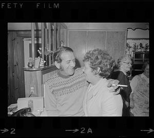 Man with cigarette and arm around woman