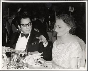 Olga Koussevitzky seated next to an unidentified man at a table