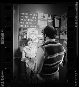 Two people stand in front of college and career posters