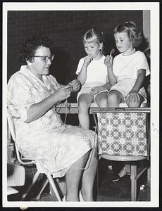 Passing Time while seeking refuge from the hurricane yesterday in Lawrence High School, Falmouth, Fern Braderick, 6, left, and her sister, Cheryl, 5, watch their grandmother, Mrs. Lawrence Burde, crochet.