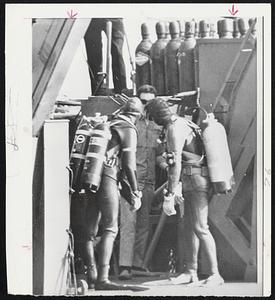 Two divers get instruction from salvage operator before they dive for tanks from the wreck of Navy minesweeper Grouse. Navy today urged salvagers not to use the tanks because they might be potential bombs.