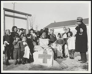 Donations Paid By Smiles. Earthquake area, Hokkaido -- Heartfelt thanks glow from the faces of these Japanese children, victims of the recent earthquake, at the town of Kirritappu as they receive warm clothing from a member of the Japanese Red Cross. A 315th Air Division C-54 Skymaster of the 374th Troop Carrier Wing flew the clothing from Tokyo to Chitose Air Force Base and other 315th personnel delivered it to the stricken area.