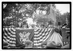 A group of people seated on a reviewing stand including Boston Parks Commissioner William Long
