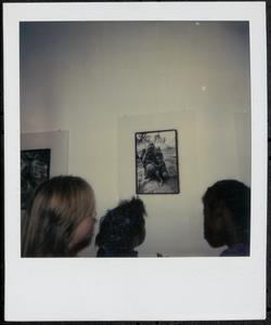 Three people looking at a photograph