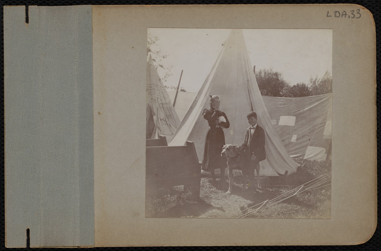 A boy and girl in front of tents
