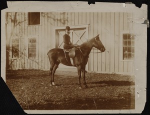Miss Kate Cary: on horseback in front of barn door