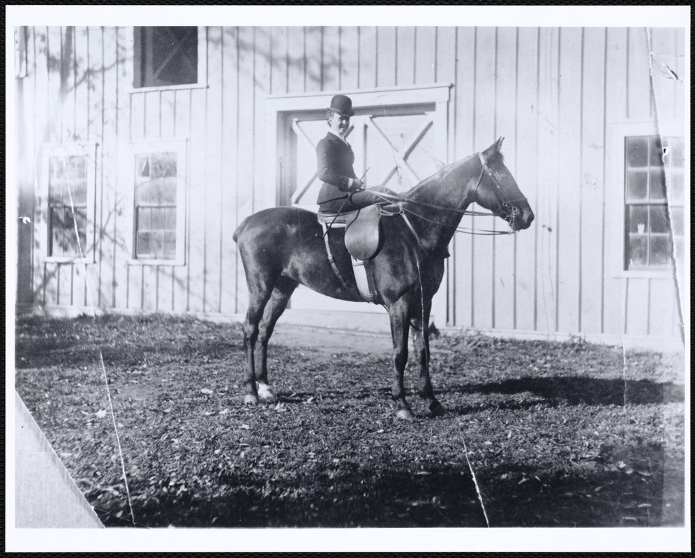 Miss Kate Cary: on horseback in front of barn door