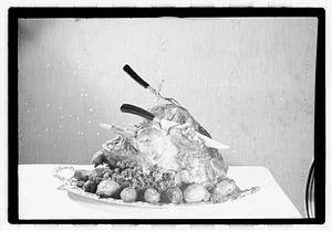 Carving knife and fork in cooked turkey