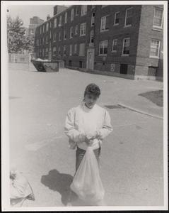 Girl holding a trash bag outside Newtowne Court