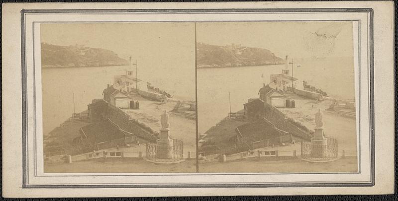 Buildings separated by a body of water, a statue in the foreground