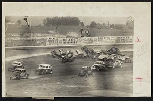 Crack-Up -- Five thousand fans screamed as 11 cars piled up on first lap of semi main event at Oakland, Calif., speedway. Despite the number of cars involved, no one was injured.