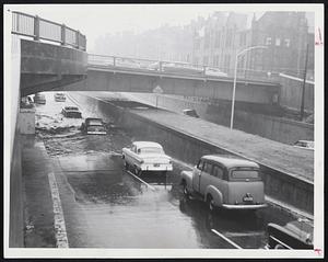 Flooded Underpass - Intown-bound traffic crawled along Storrow drive at the Massachusetts avenue underpass yesterday afternoon, fording a foot-deep pool of water that collected during the heavy rains. More than four and one-half inches of rain fell on city during storm, a near-record rainfall.