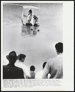 Seven Drown--Divers (in water near boat) pulled seven members of two Gainesville, Ga., families from Lake Lanier Christmas Day. Only four of 11 persons--two adults and two children--riding in the car to get apples for Christmas dinner escaped drowning. The car plunged down a 30-foot embankment into the lake.